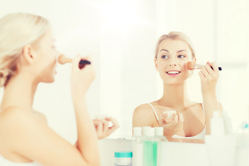 Obraz na płótnie Canvas woman with makeup brush and powder at bathroom