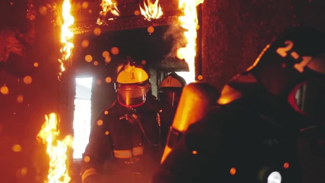 a firefighter knocks out the burning door