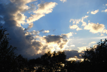 Beautiful sky at sunset, with dark clouds framed by the sun