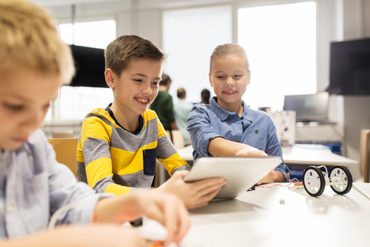 kids with tablet pc programming at robotics school