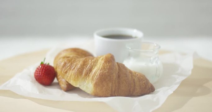 Close-up view of delicious croissants on plate with cup of coffee. 