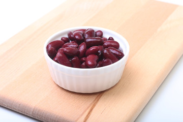 Heap of canned red kidney beans in the sauce in white bowl. vegetarian food. Phaseolus vulgaris.