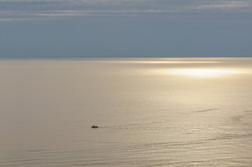 Lonely fisherman is sailing home before sunset along the Tyrrhenian coast - Maratea, Basilicata, Italy