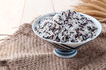 Rice in a bowl on a wooden background.
