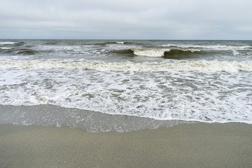 Fototapeta premium Landscape with The Black sea, sand and beach elements photographed in Gura Portitei, Romania, in a foggy spring day