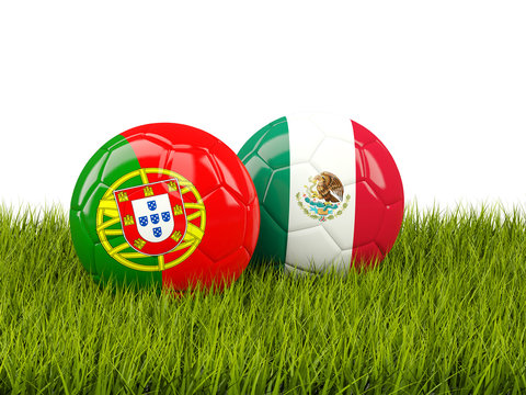 Two footballs with flags of Portugal and Mexico on green grass