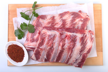 Raw pork ribs with herbs and spices on wooden board. Ready for cooking.