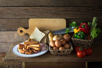 Sausage, ham and bacon in white dish and ingredient for prepare breakfast