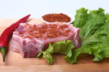 Raw pork chops with herbs and spices on cutting board. Ready for cooking.