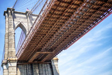 Obraz premium Underside of the Brooklyn Bridge as seen from Brooklyn Bridge Park across the East River from Manhattan.