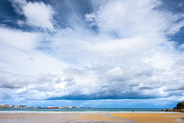 Atlantic sandy beach in Spain with city of Coruna background.
