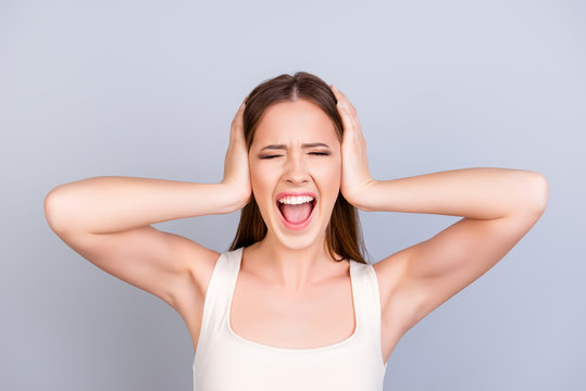 Stop it! Silence! Quiet! Close up of a stressed yelling teen with closed eyes and ears. She is in a casual white singlet on a pure light background