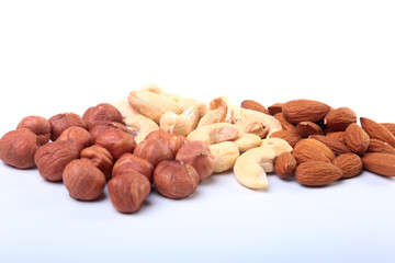 Mixed nuts from hazelnuts, almonds, cashews isolated on white background. Selective focus.
