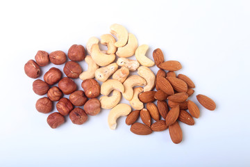 Mixed nuts from hazelnuts, almonds, cashews isolated on white background. Selective focus.