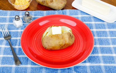 Buttered Baked Potato on Red Plate