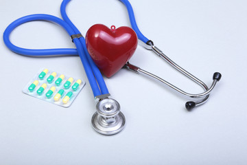 RX prescription, Red heart, asorted pils and a stethoscope on white background