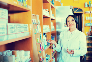 Woman in white coat promoting health supplements in drugstore