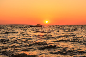 sea and boat at sunset