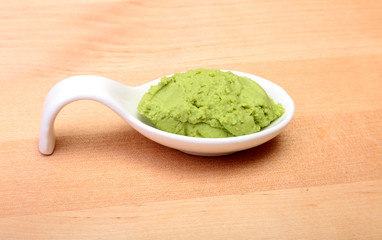 plate with Japanese wasabi sauce on wood background.