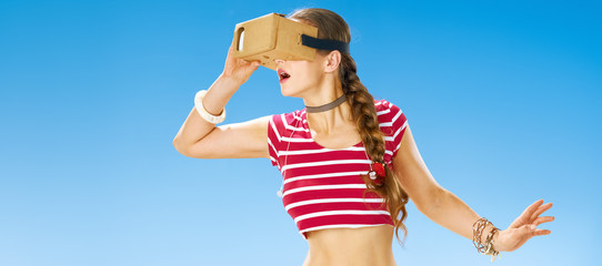 excited fit woman on seashore using VR headset