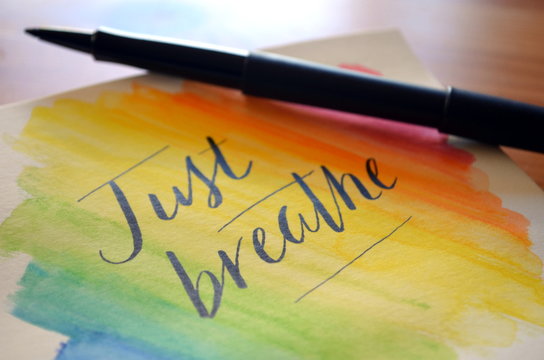 JUST BREATHE handwritten on notepad