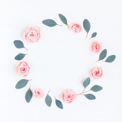 Flowers composition. Wreath made of pink rose flowers and eucalyptus leaves on white background. Flat lay, top view