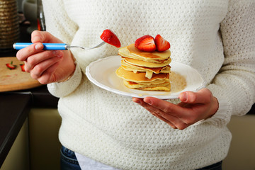 Tasty beautiful pancakes on white shirt, in female hands, healthy lifestyle