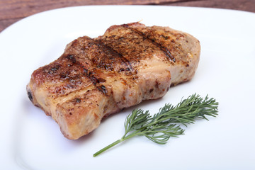 grilled pork chop on plate on wooden board