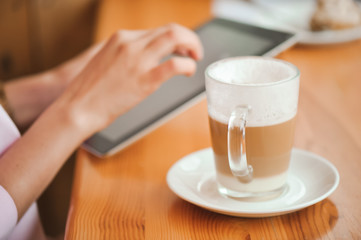 Close up hand woman using tablet in coffee shop
