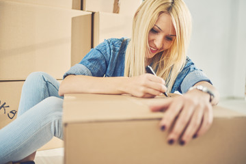 Caucasian girl using marker for writing on boxes