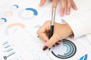 Businesswoman hand with pen writing on graph