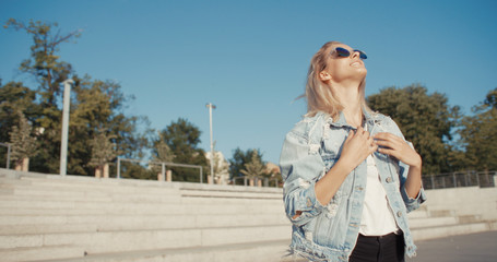 Young fashion woman in a city in Europe. Happy stylish girl in sunglasses enjoying summer.