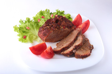 Steak of grilled meat with tomato, lettuce and beans pomegranate on white plate.
