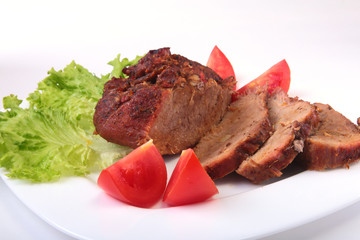 Steak of grilled meat with tomato, lettuce and beans pomegranate on white plate.