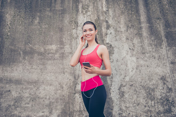 Summer, wellbeing, wellness, music and work out! Sporty young lady in fashionable sport wear is listening to music and smiling, will start her training now