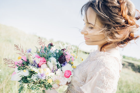 Portrait of beautiful bride with bouquet in nature. fine art photography.