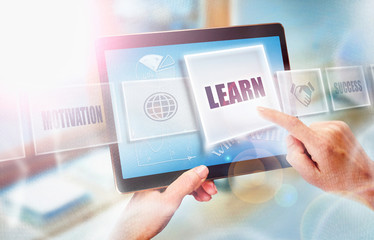 A businesswoman selecting a Learn business concept on a futuristic portable computer screen.