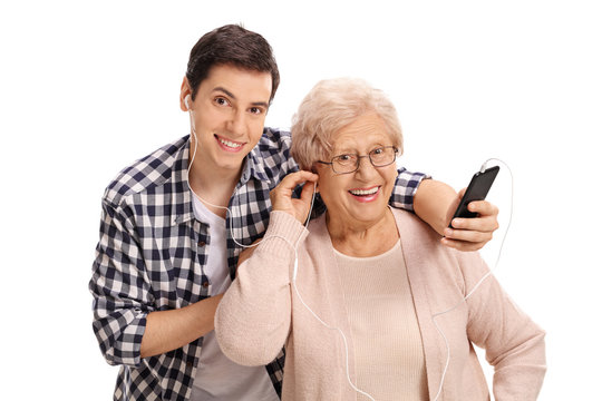Mature woman listening to music on phone with her grandson