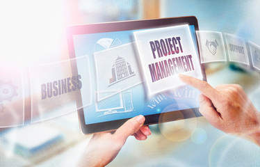 A businesswoman selecting a Project Management business concept on a futuristic portable computer screen.