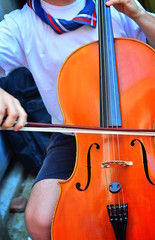Young musician plays cello in a school. © liberowolf