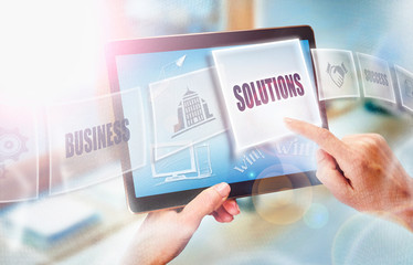 A businesswoman selecting a Solutions business concept on a futuristic portable computer screen.