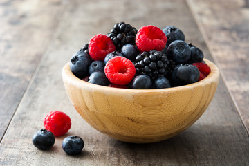 Healthy berries in wooden bowl on wooden table
