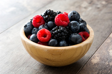 Healthy berries in wooden bowl on wooden table
