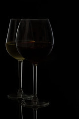 Wine glasses on black - two glasses of red and white wine