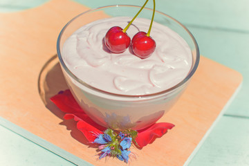 Delicious curd dessert soufflé with cherry decorated with flowers