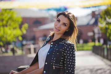 Stylish woman in a leather jacket walks around the city. Look back