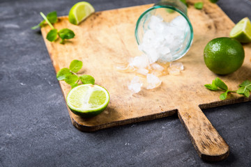 Mojito Cocktail.Mint, lime, ice ingredients for making.Cold Drink Chopping board on the Gray Concrete Background..Top View.Copy space for Text.selective focus.