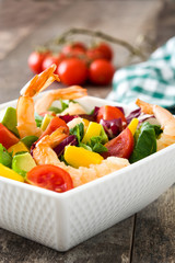Shrimps salad with mango and avocado on wooden table
