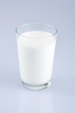 Glass of milk isolated on the light blue background