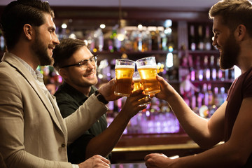 Cheerful young men toasting with beer